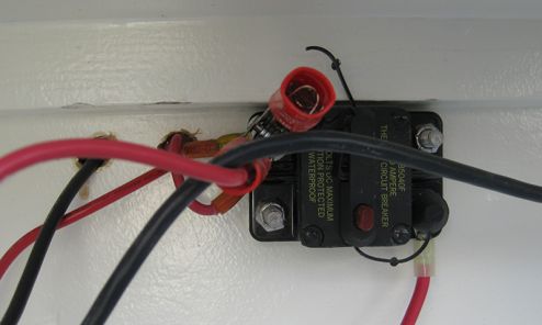 Just above the battery and below the port shelf, a master circuit breaker	was installed on the positive line for the boat