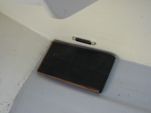 I cut an appropriate sized piece of half-inch plywood to support the battery in the gap next to the bulkhead