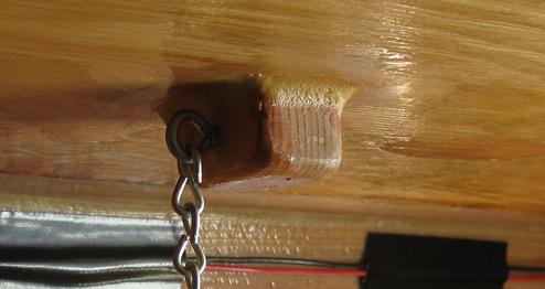 Eyebolt is fastened to a wood block mounted to the ceiling of the cabin
