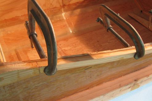 The coaming piece butts up against the strip of wood coming from the top of the cabin's side