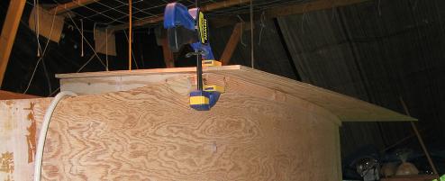 The panels are clamped down, and their outboard shape is traced from below using the cabin sides as a guide