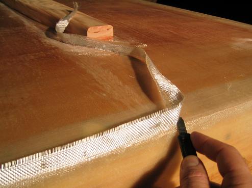 Before the epoxy fully hardens, take a razor knife and cut away the excess cloth