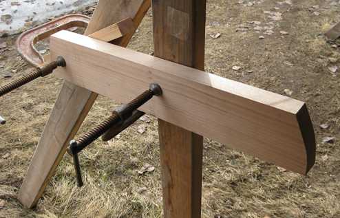 Pivot block of wood being shaped by a belt sander