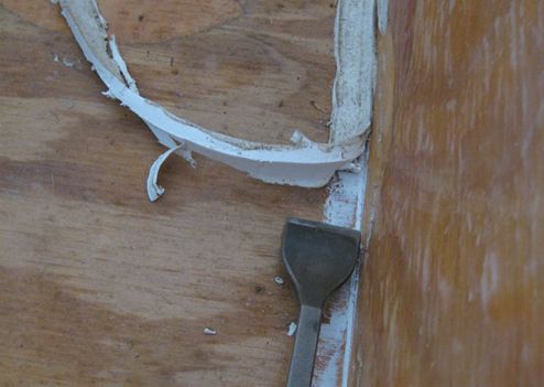 Working to remove old caulking